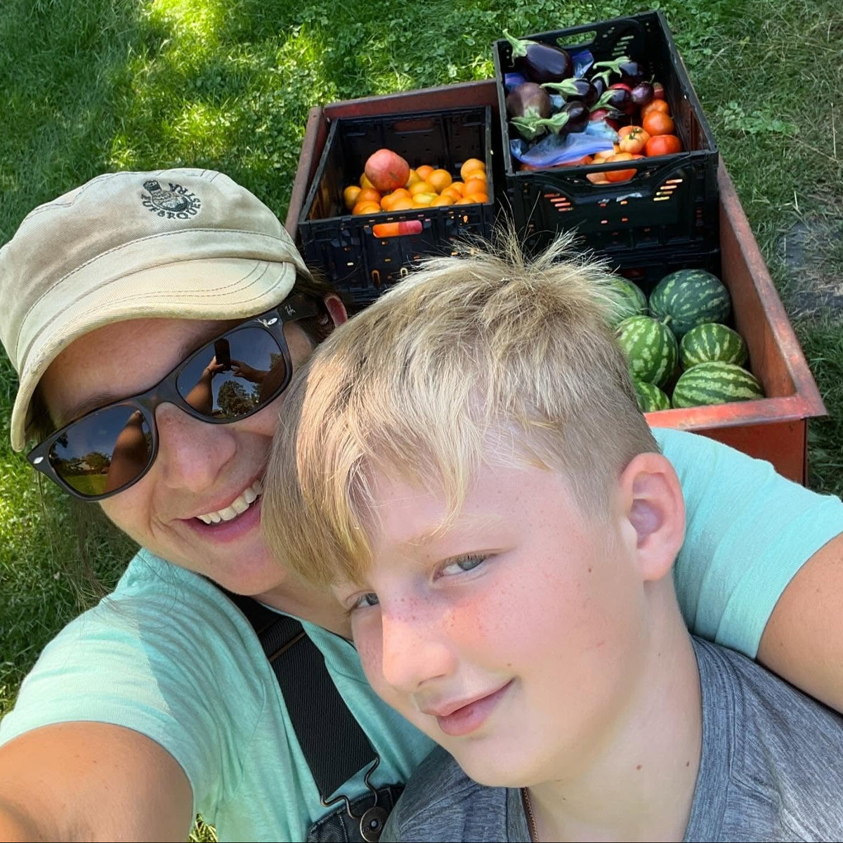 Jenny and Lewis with a cart full of fruits and vegetables on a grassy background